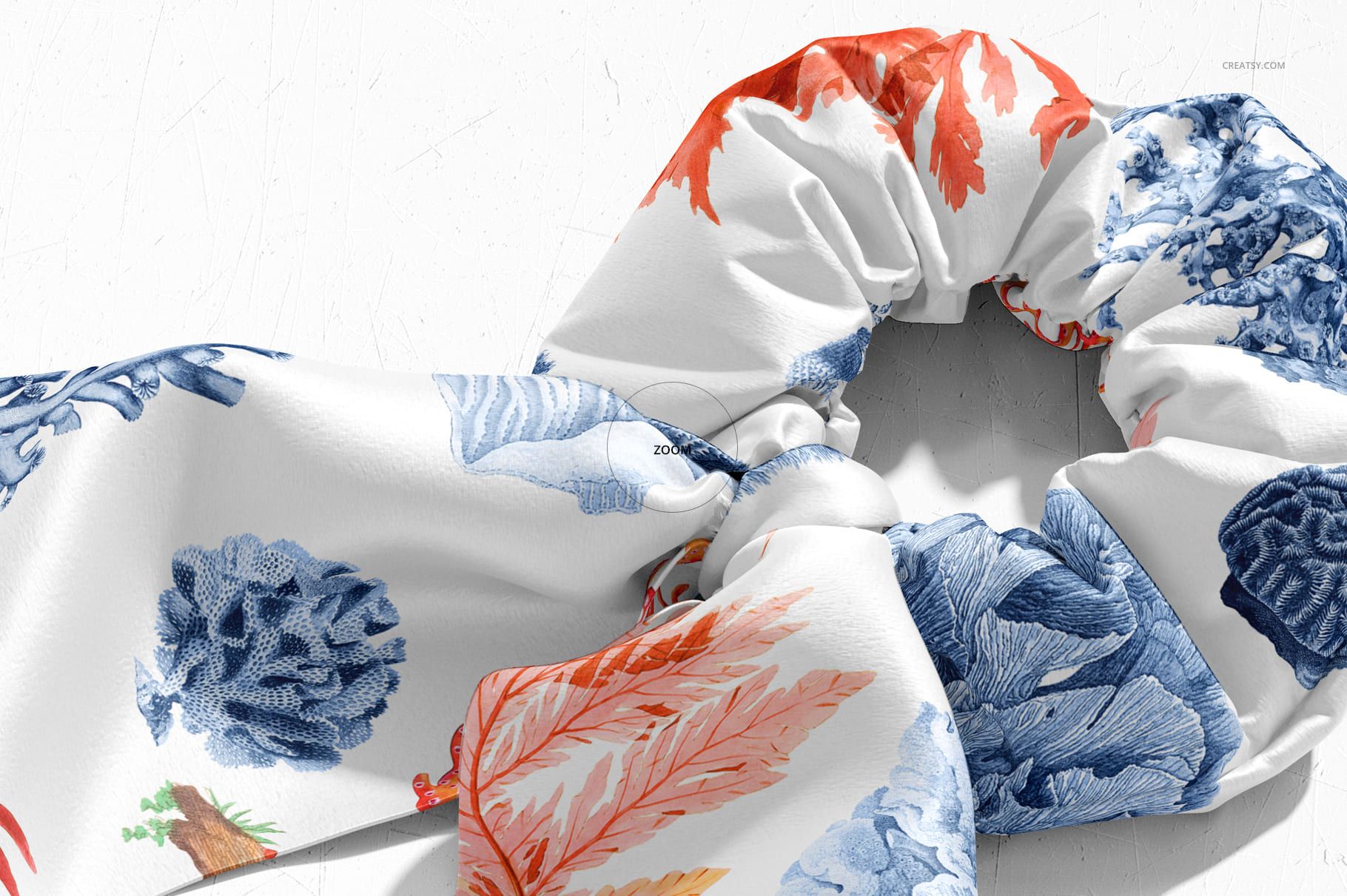 Scrunchie scarf mockup featuring detailed blue and orange leaf designs, displayed from a top-down perspective.