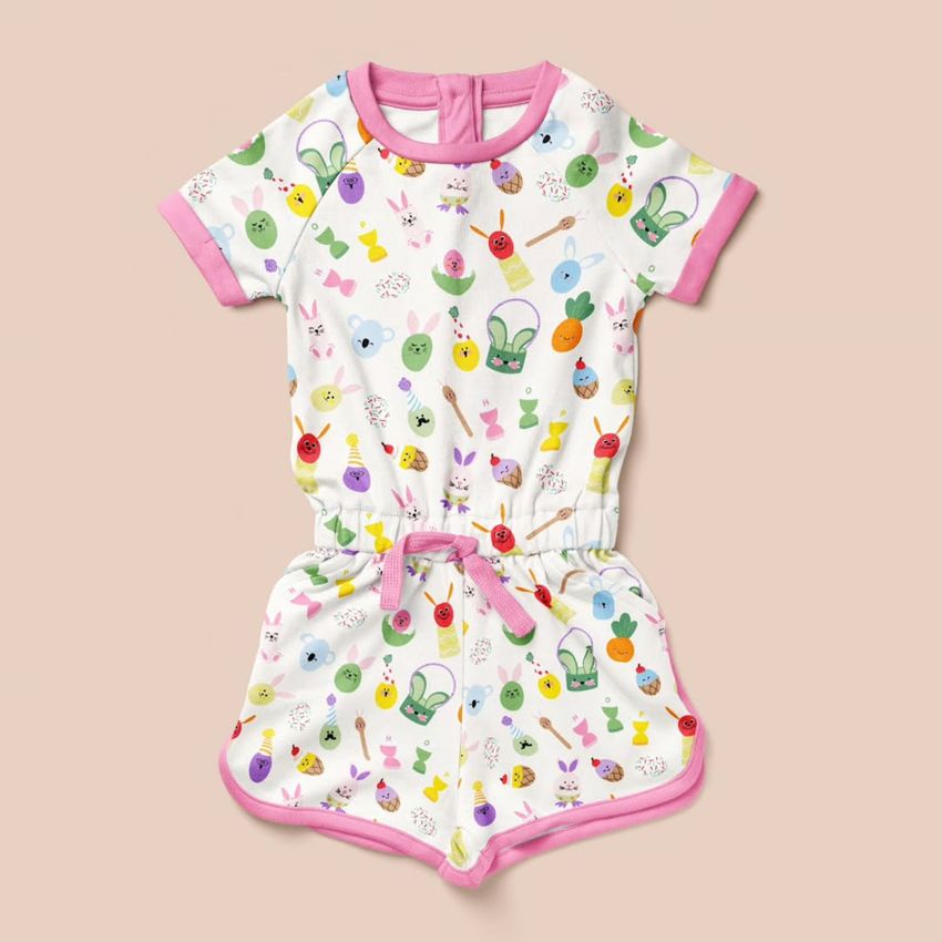 Girls cotton playsuit mockup featuring a colorful Easter-themed pattern with eggs, bunnies, and spring motifs on a beige background.