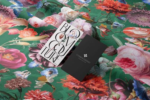 Top view of green cotton fabric with colorful flowers and two business cards, shown in a realistic PSD mockup scene.