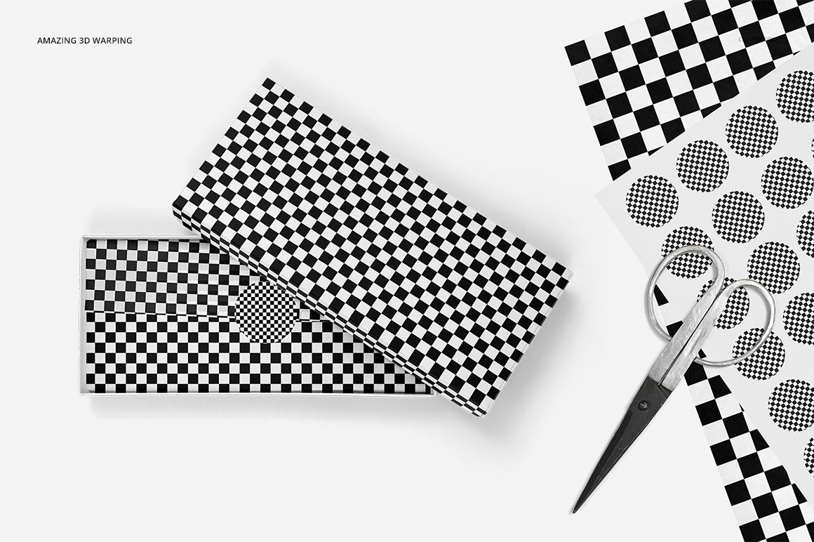 Black and white patterned tissue paper mockup featuring a gift box, loose sheets, and scissors arranged in a minimal scene.