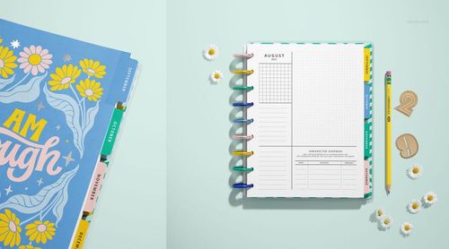 PSD mockup of a spiral planner featuring pastel dividers, open layout, and decorative daisies on a blue background.