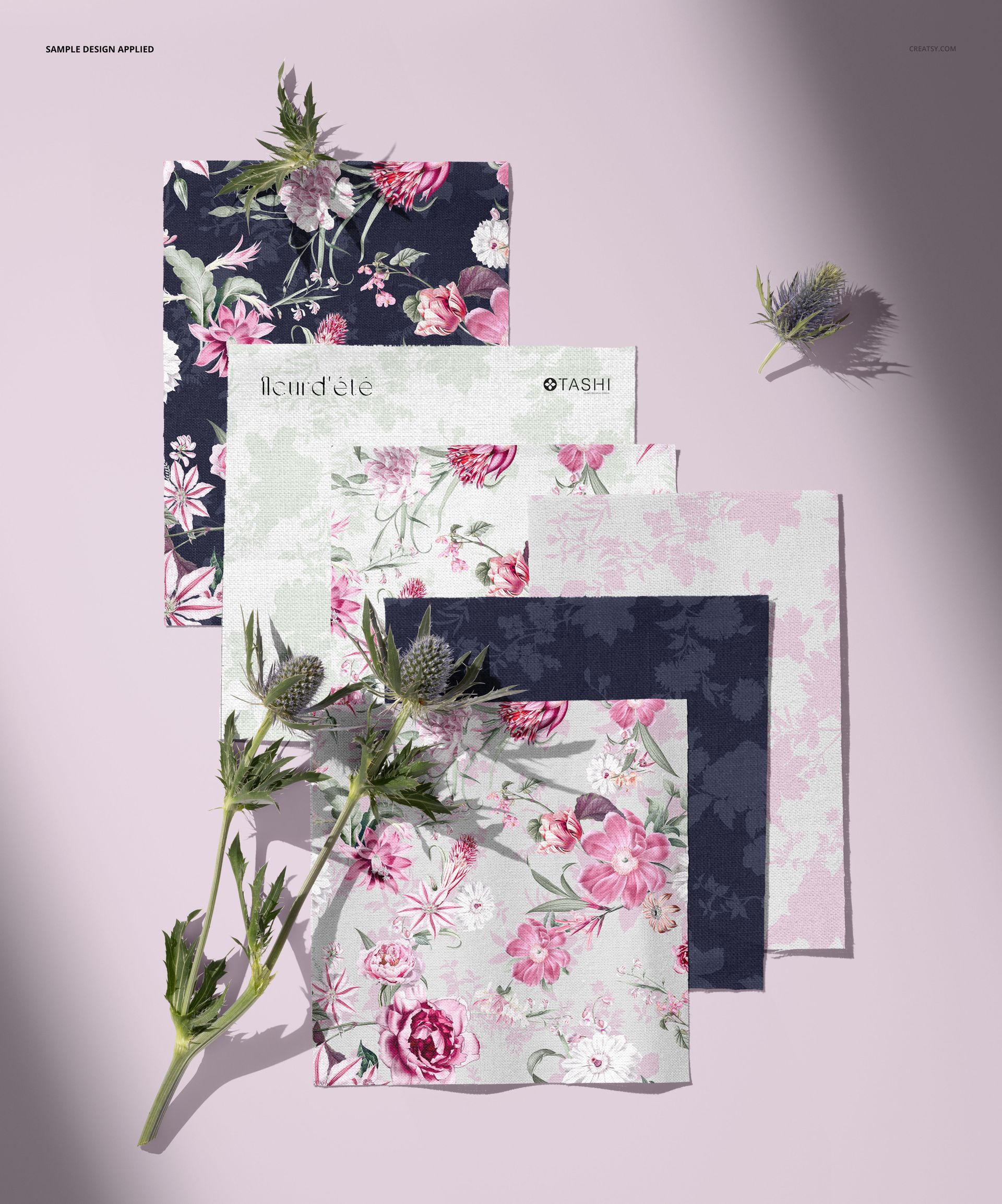 PSD mockup showing cotton fabric samples in various floral designs, set against a soft pink backdrop with thistles.