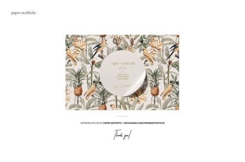 Spiral planner mockup placed on sand, featuring a tropical leaf and pineapple pattern with a round label.