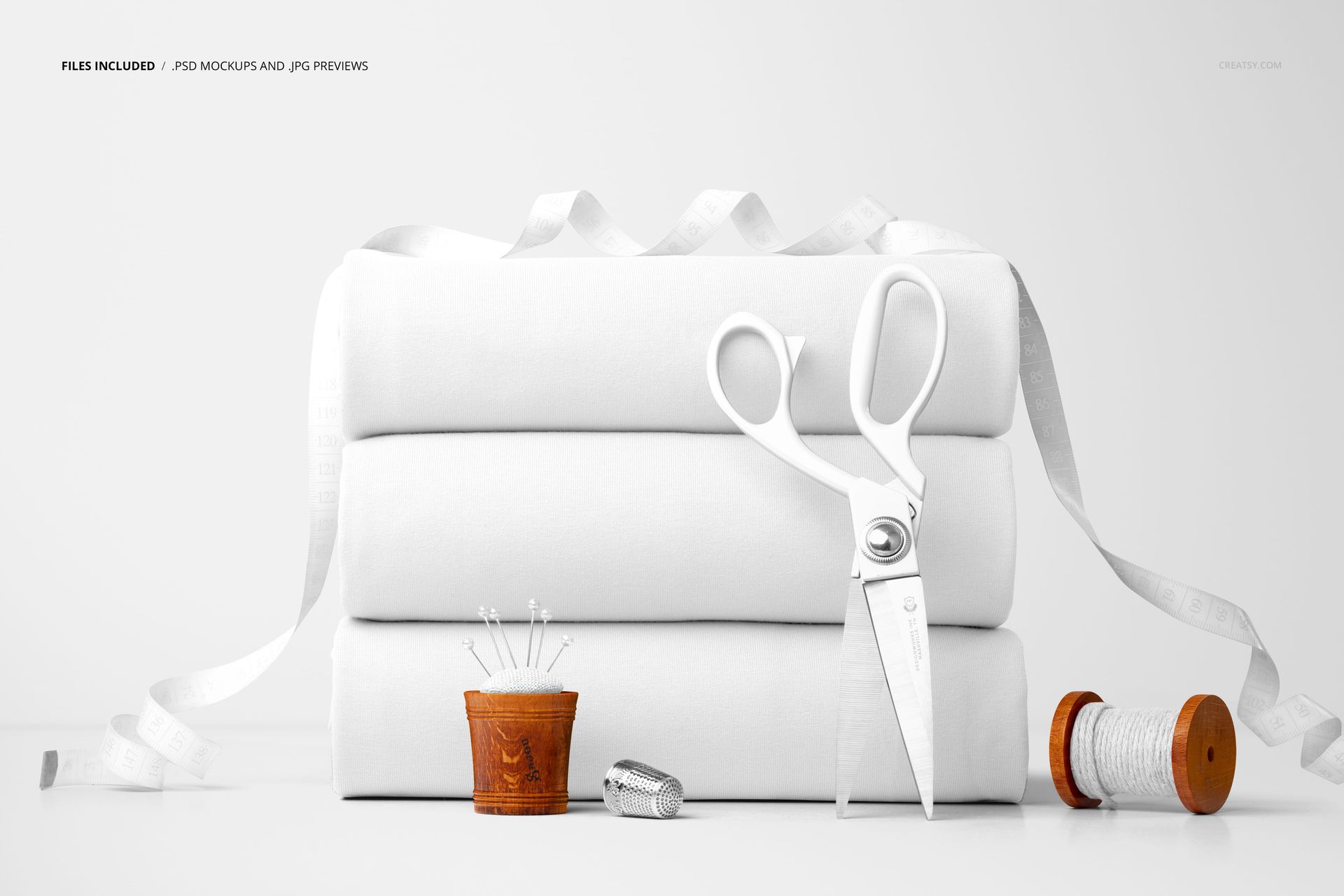 White jersey fabric mockup in PSD format, shown with sewing items such as a thimble, pins, and measuring tape.