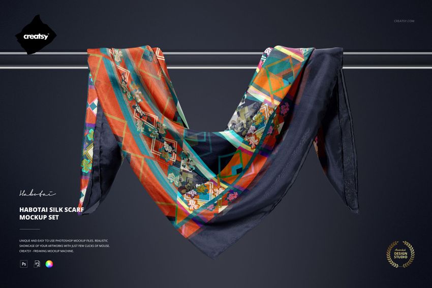 Silk scarf mockup draped over a horizontal metal rod, featuring colorful geometric and floral patterns on dark fabric.