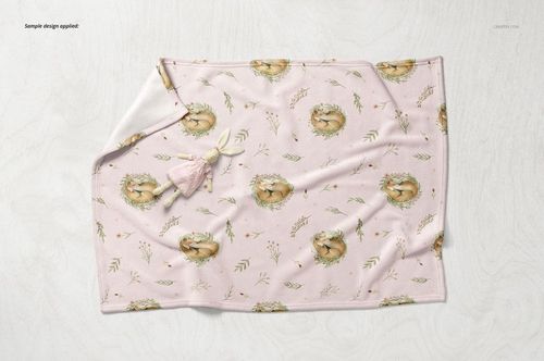 Soft fleece baby blanket mockup displayed flat on a light surface, featuring a pastel animal pattern and a small plush toy.