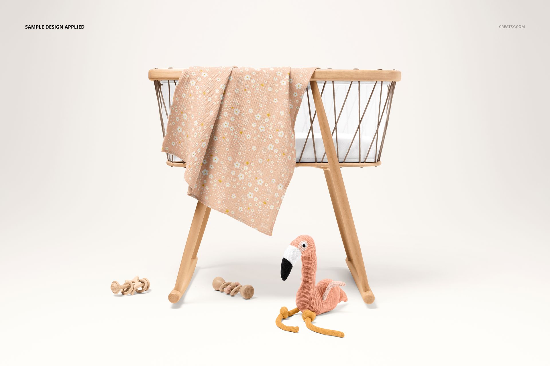 PSD mockup of a crinkle muslin swaddle blanket featuring a delicate floral print, displayed on a wooden crib.