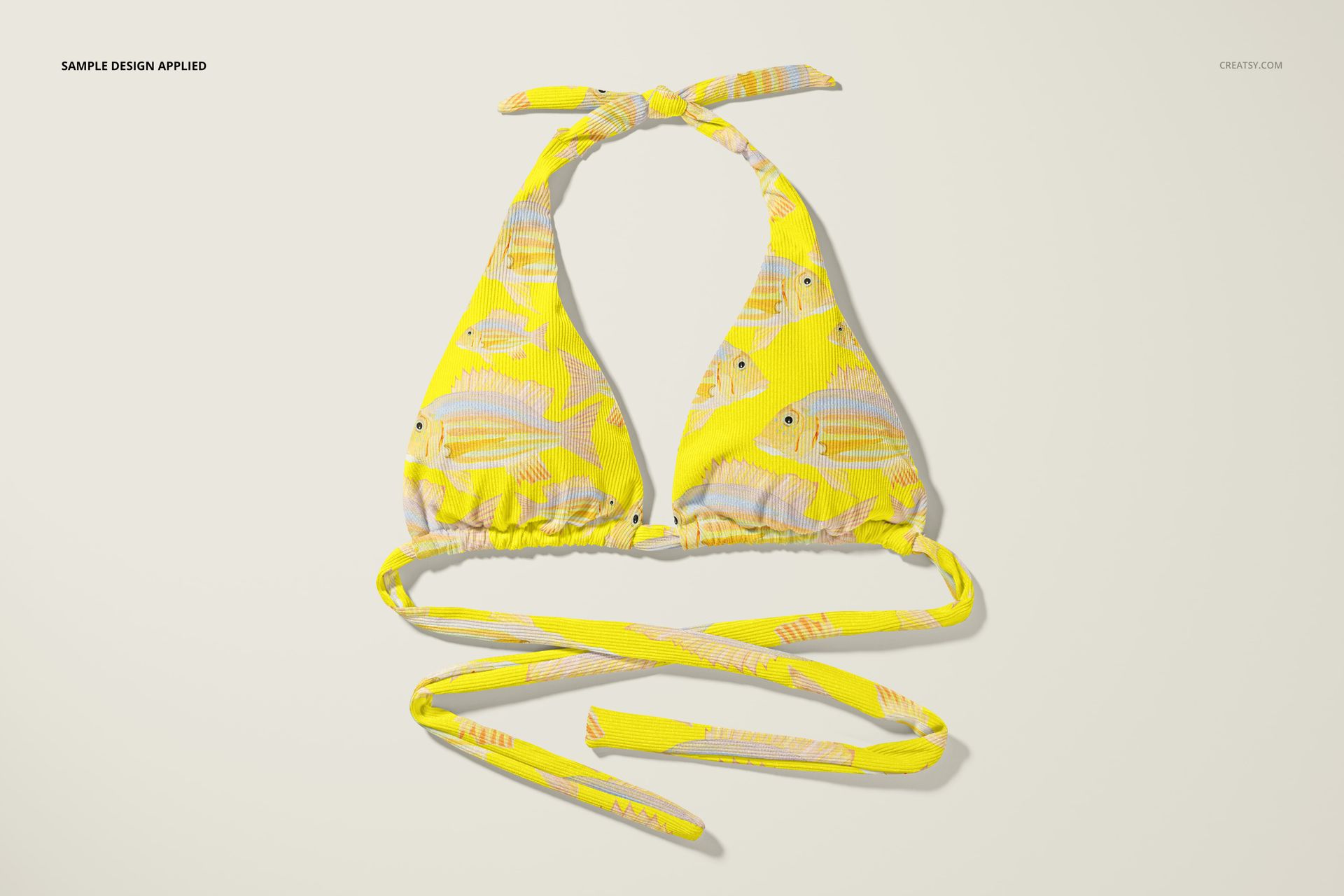 High waisted bikini top mockup with yellow fabric featuring a fish pattern, displayed from a top-down perspective.