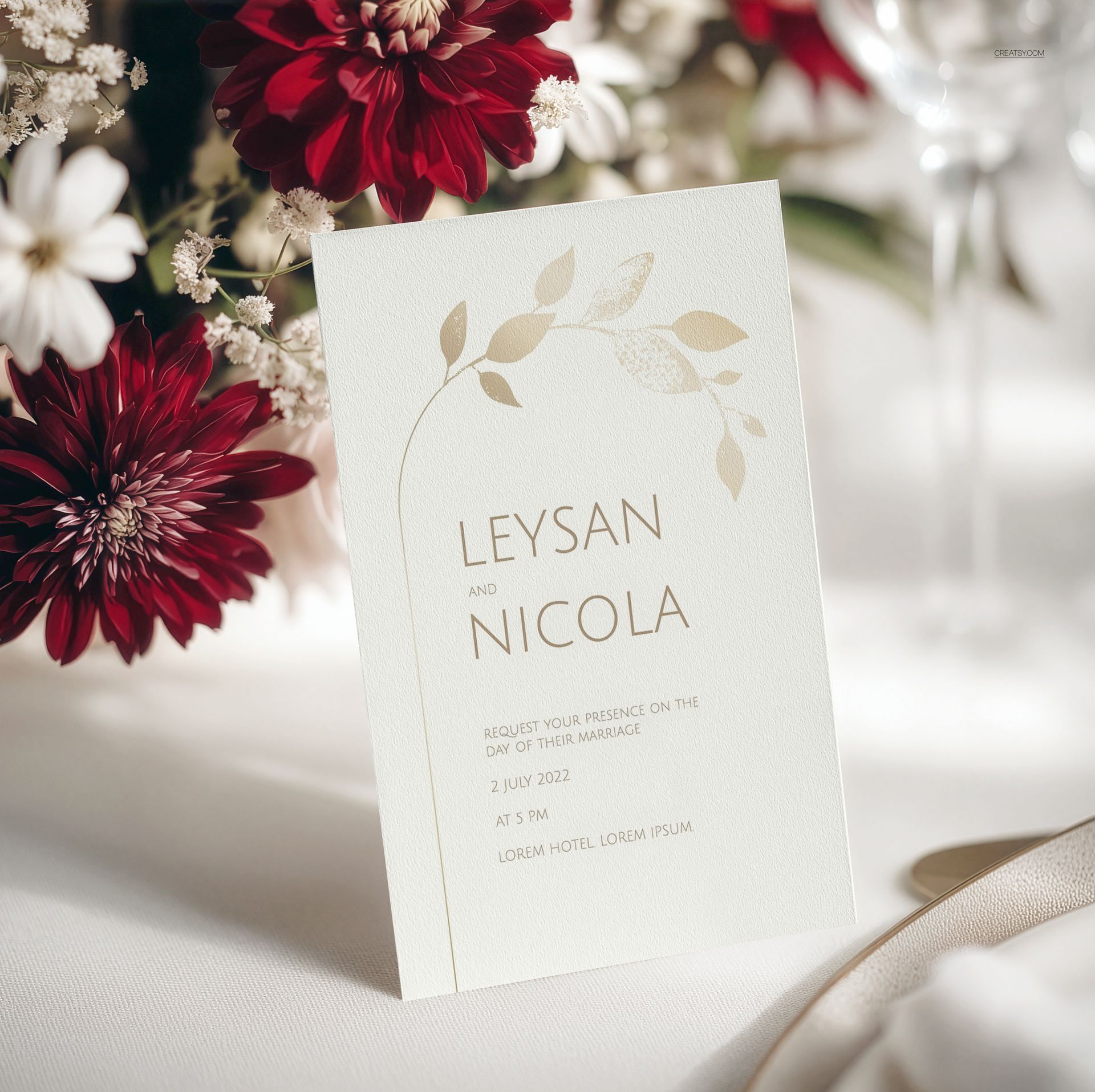 Floral wedding menu card mockup displayed upright on a white table, surrounded by red and white flowers.