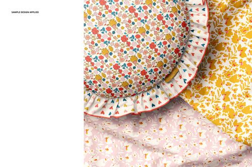 Round ruffled pillow mockup with multicolor flower print, displayed with yellow and pink patterned textiles.