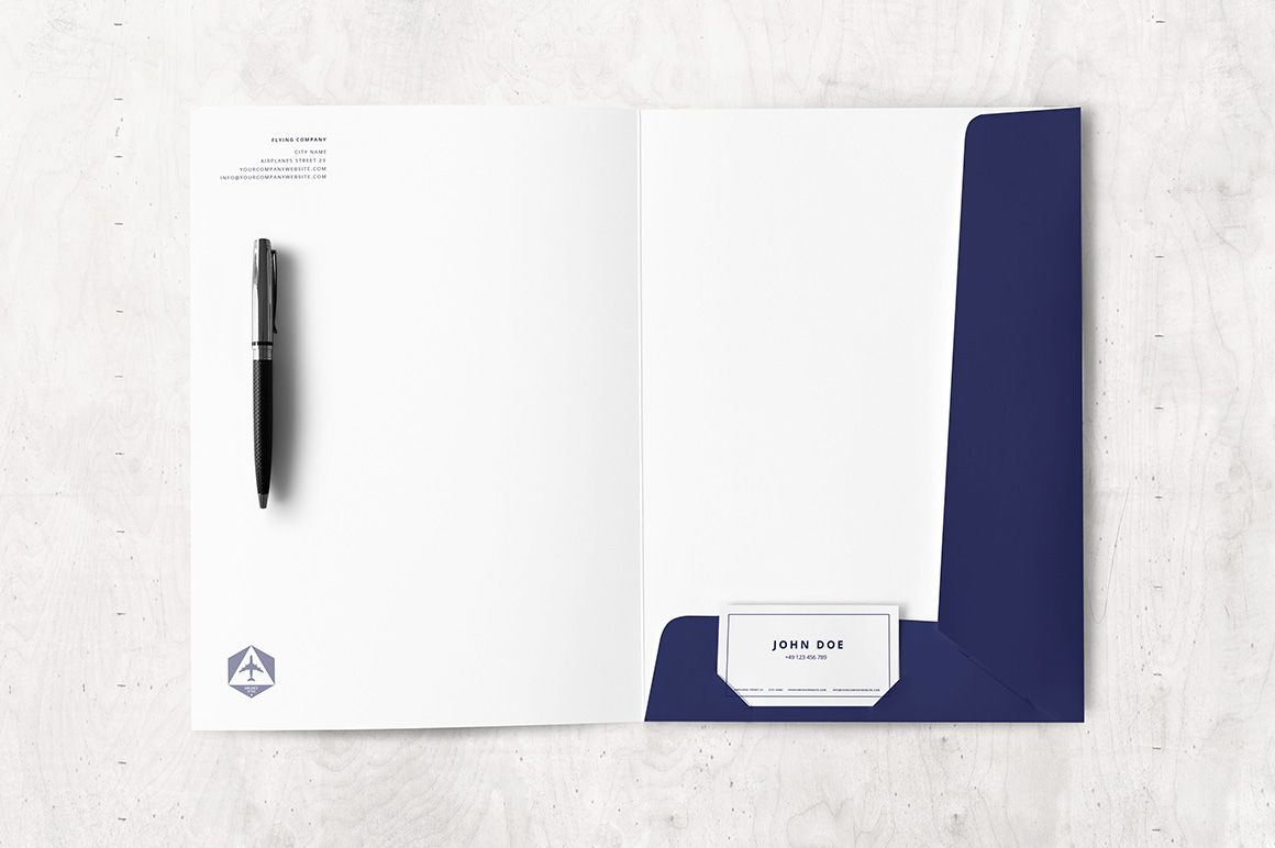 Open folder mockup with dark blue interior pocket, white letterhead, pen, and business card on a light surface.