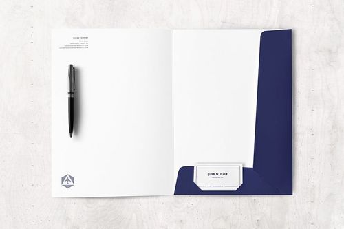 Open folder mockup with dark blue interior pocket, white letterhead, pen, and business card on a light surface.
