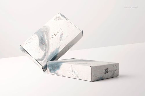 PSD mockup of two packaging boxes with a soft marble texture, one box stacked on another in a minimalist scene.