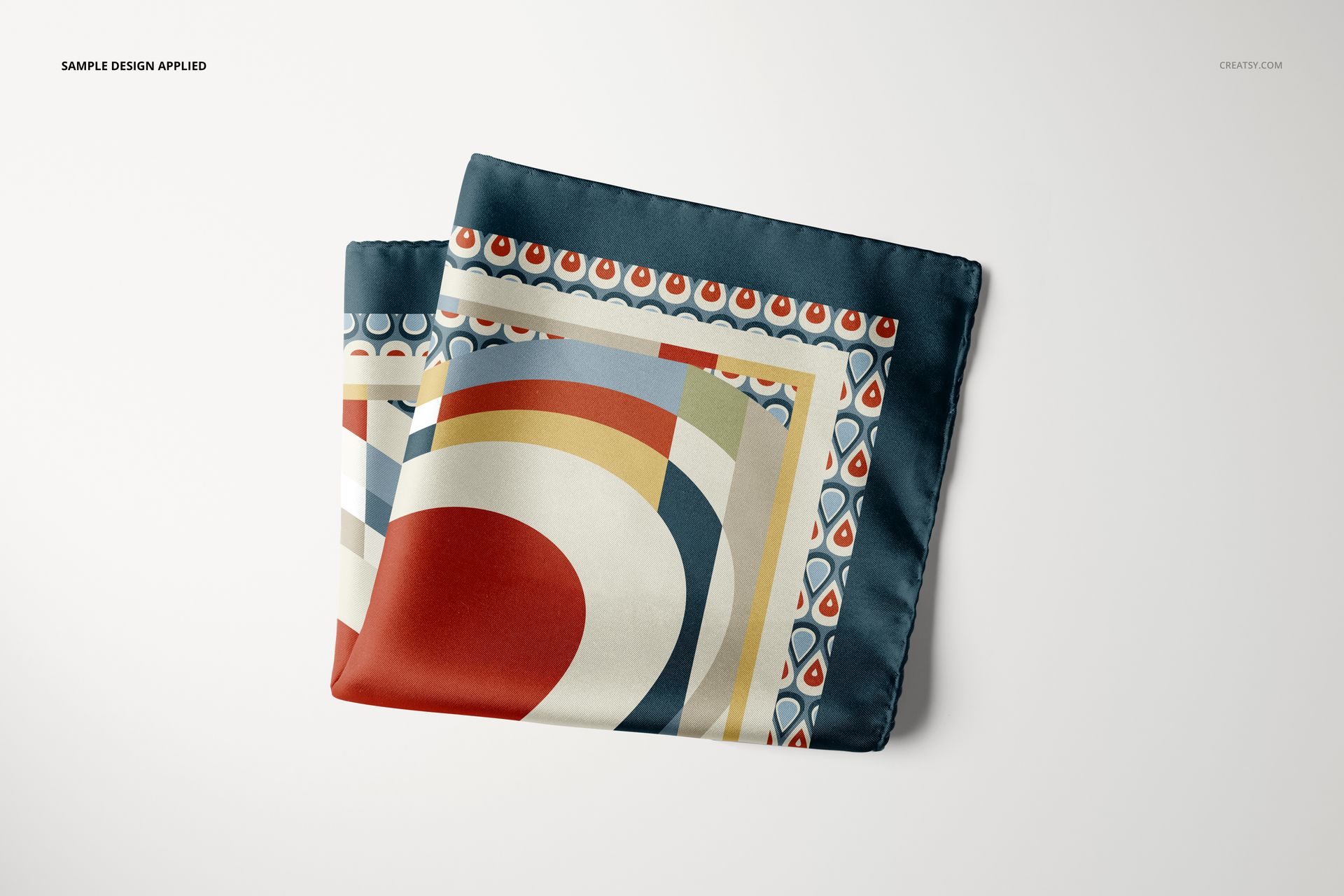Folded pocket square mockup featuring geometric and abstract patterns in red, blue, beige, and white on a plain surface.