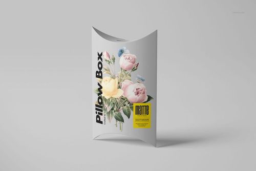 Matte pillow box with floral illustration, standing upright on a light gray surface, front view mockup.