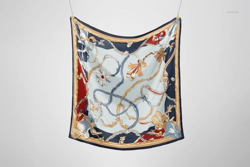 Square silk scarf mockup featuring intricate floral and rope designs in navy, gold, and cream, front view.
