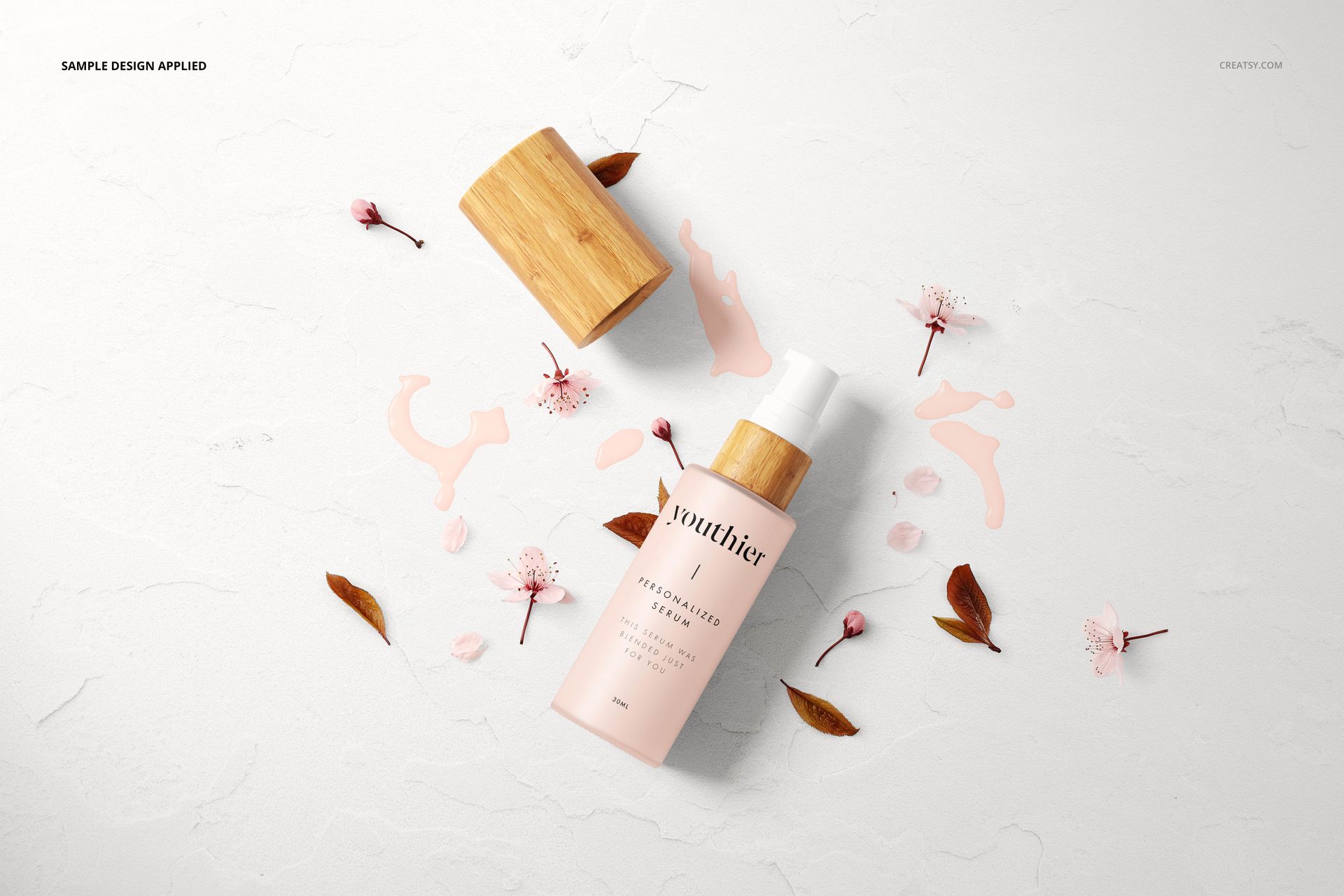 Front view of a cosmetic bottle mockup with a wooden lid, pink floral accents, and scattered leaves on a light background.