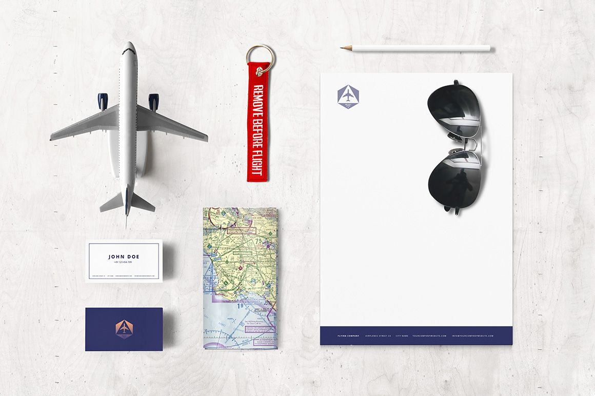 Top view of airline-themed stationery mockup with business cards, letterhead, pencil, sunglasses, keychain, and airplane model.