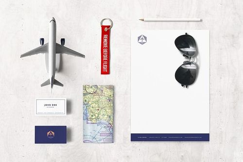 Top view of airline-themed stationery mockup with business cards, letterhead, pencil, sunglasses, keychain, and airplane model.