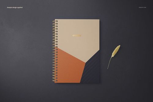 Top view of an A5 spiral notebook mockup with square holes, geometric cover design in beige, orange, and navy.
