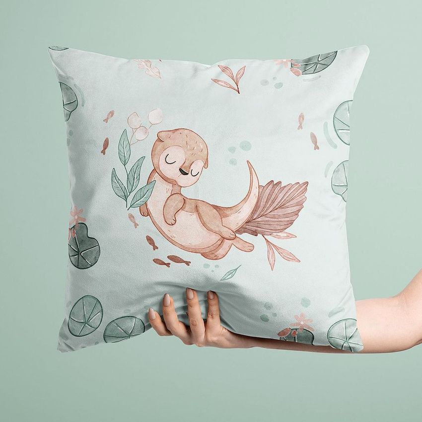 Velvet cushion cover mockup featuring a hand holding a square pillow with a cute otter illustration and pastel leaf patterns.