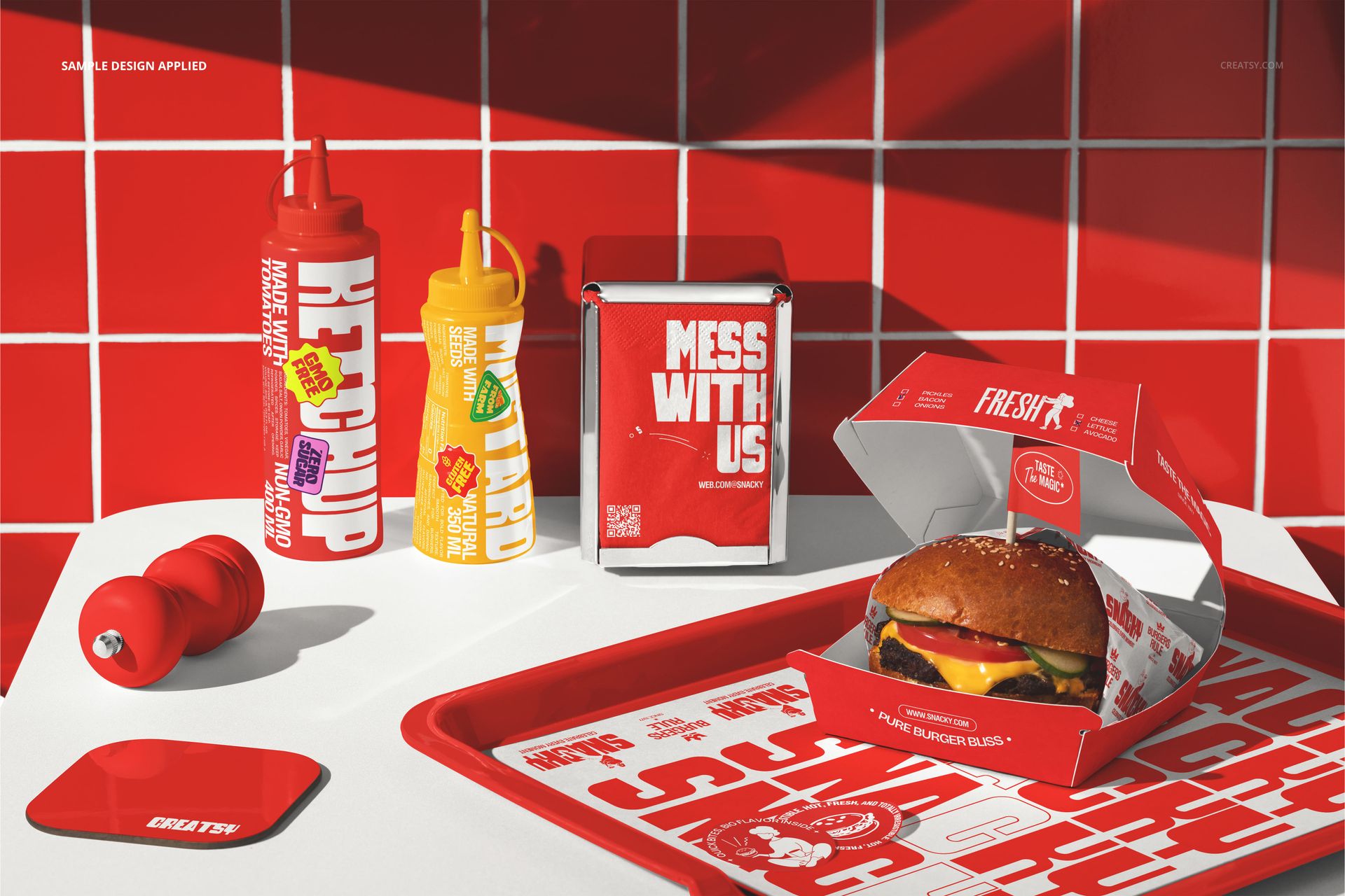 Fast food branding mockup featuring a burger in an open box, condiment bottles, napkin holder, and branded tray on a red tiled surface.