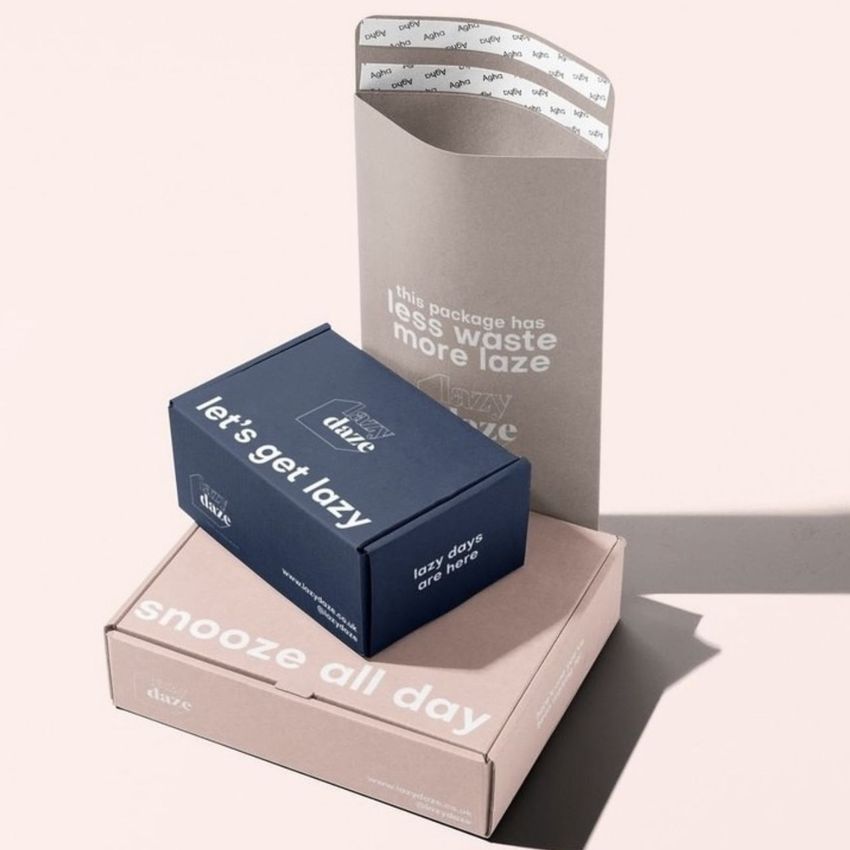 Packaging mockup featuring three boxes in kraft and pastel shades, arranged on a light surface with soft shadows.