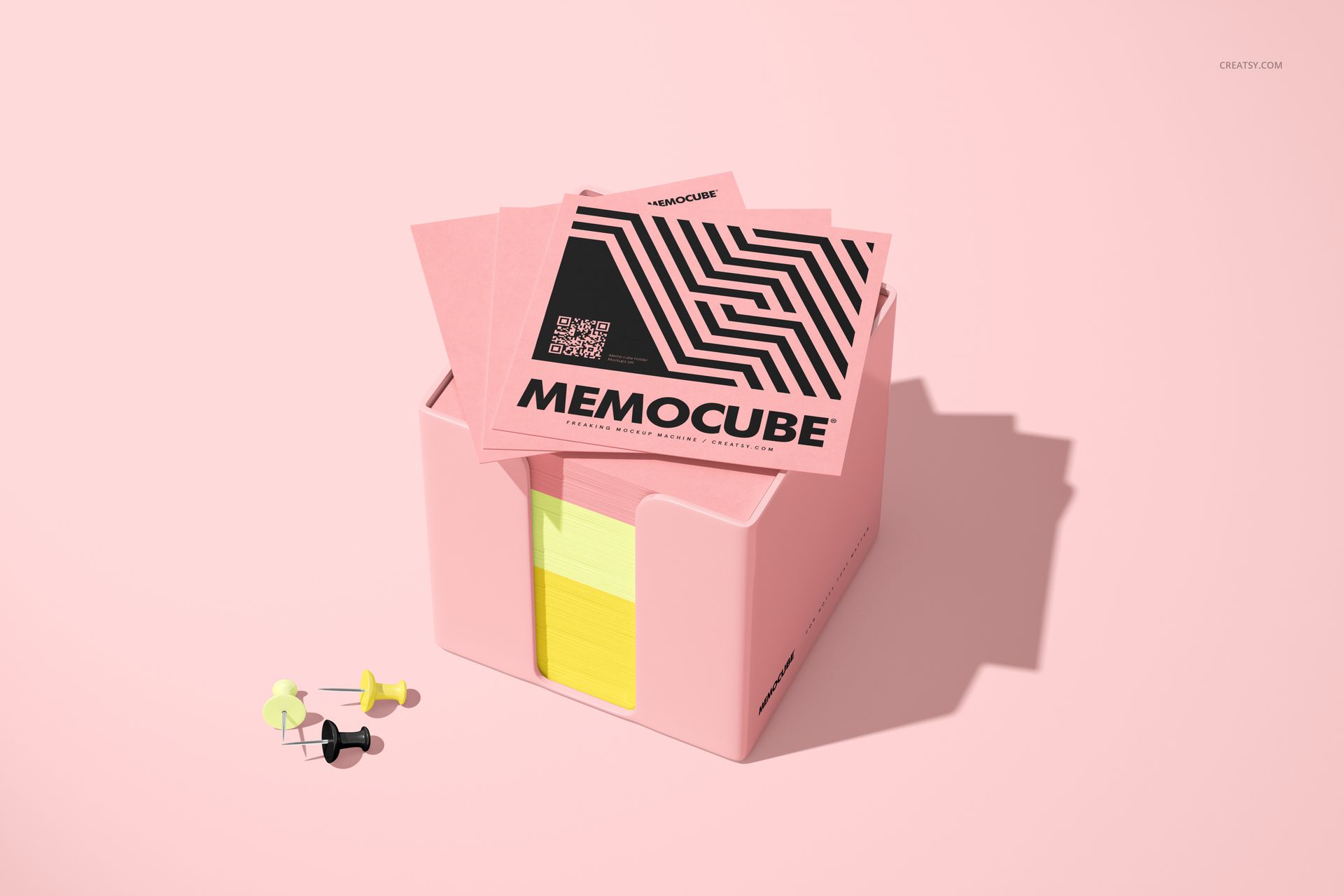 PSD mockup showing a memo block cube in a pink acrylic holder, yellow paper sheets, and pink covers on a light pink surface.