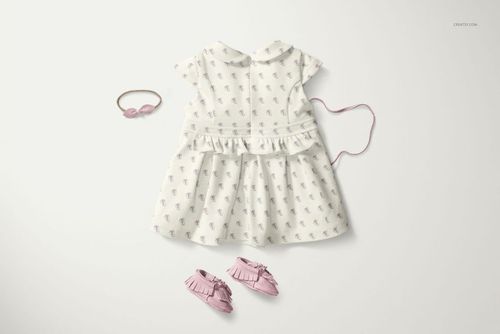 PSD mockup of a baby dress featuring a Peter Pan collar, soft pattern, and pink accessories on a light surface.