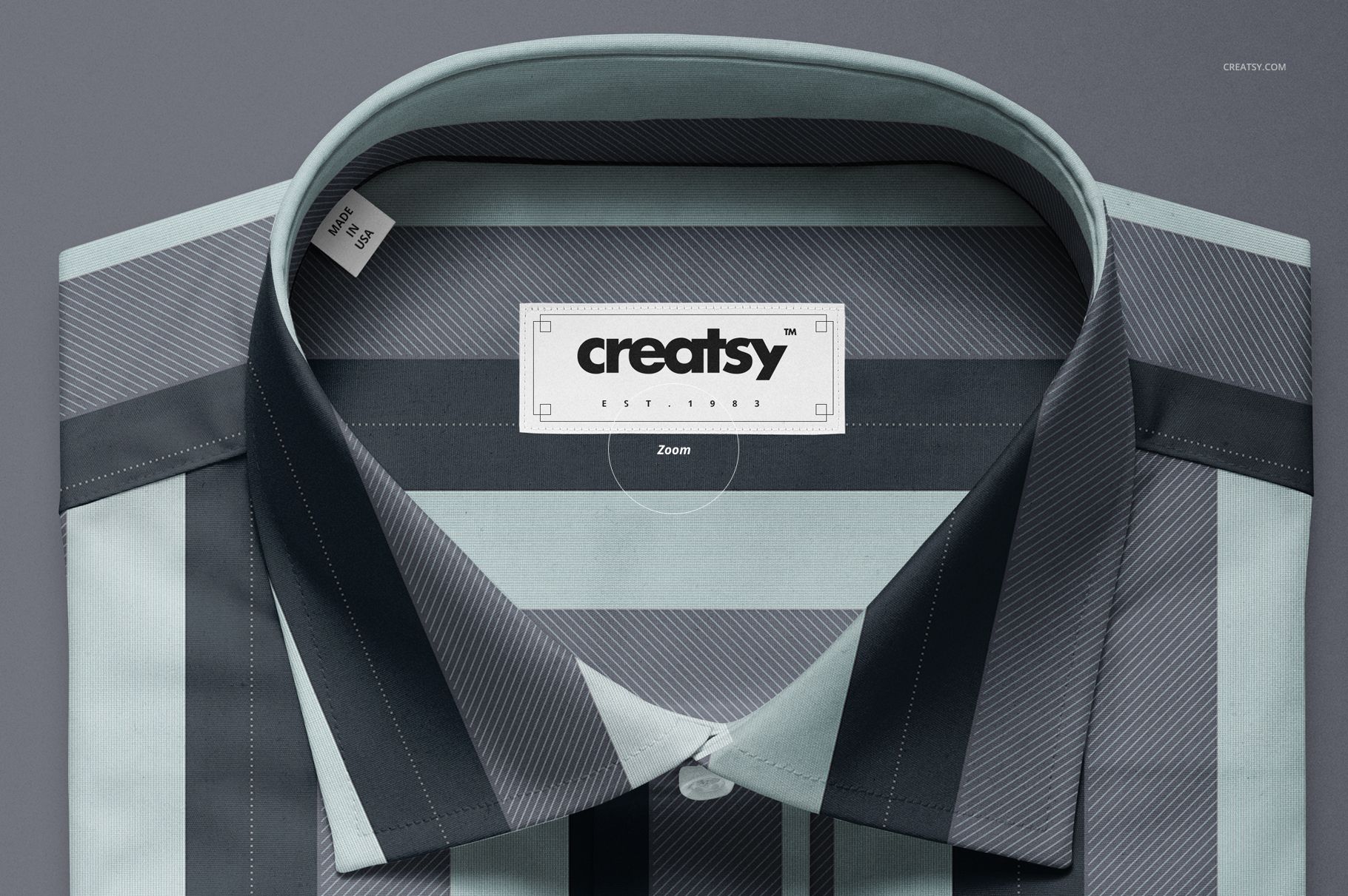 Top view of a folded dress shirt mockup with a geometric striped pattern in gray, blue, and black tones.