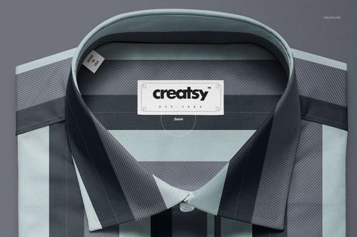 Top view of a folded dress shirt mockup with a geometric striped pattern in gray, blue, and black tones.