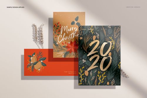 Stationery mockup set displaying three cards with floral and seasonal artwork, photographed from a top-down perspective.