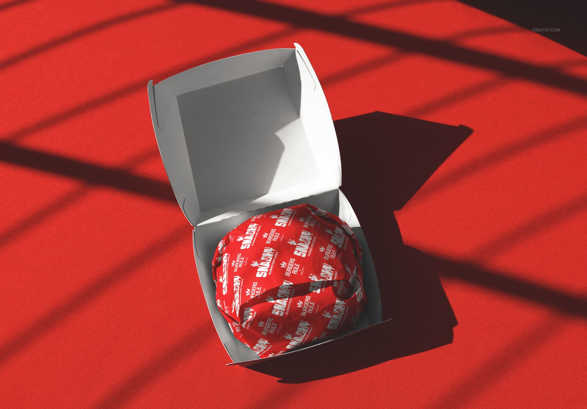 Open burger packaging mockup featuring a wrapped burger in a white box, placed on a vibrant red background.