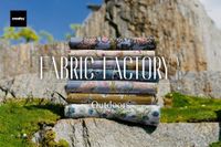 Stack of patterned fabric pieces arranged outdoors on mossy rocks, featuring floral and botanical designs.