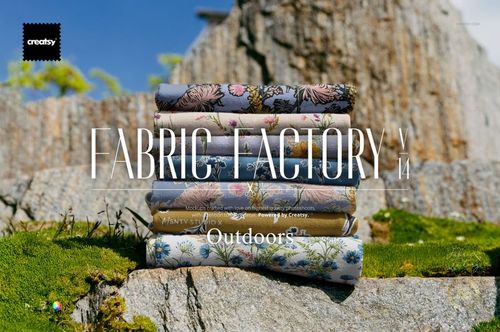 Stack of patterned fabric pieces arranged outdoors on mossy rocks, featuring floral and botanical designs.