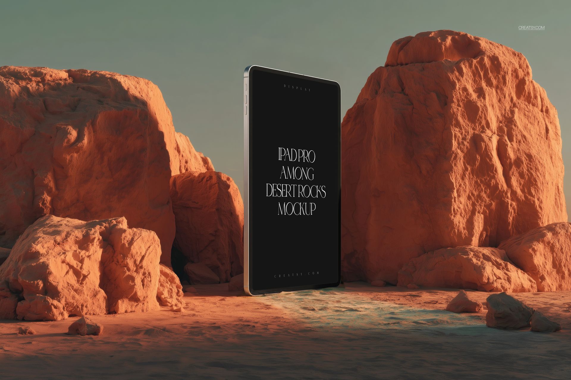 PSD mockup of an iPad Pro positioned vertically between orange desert rocks, front view with shadows on sand
