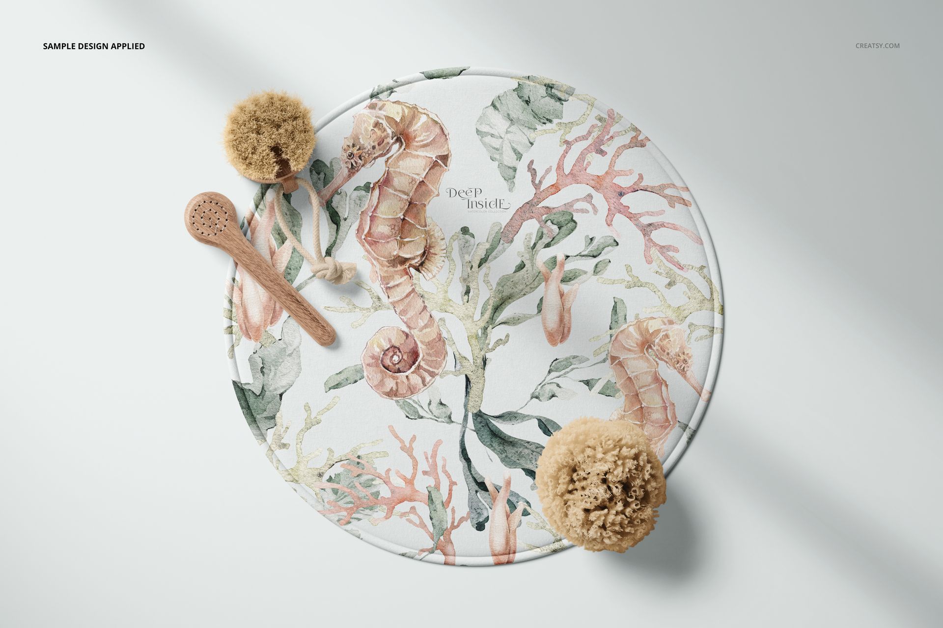 PSD mockup of a 28 inch round bath mat with botanical and ocean-themed illustrations, displayed with natural bath props.