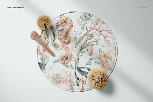 PSD mockup of a 28 inch round bath mat with botanical and ocean-themed illustrations, displayed with natural bath props.
