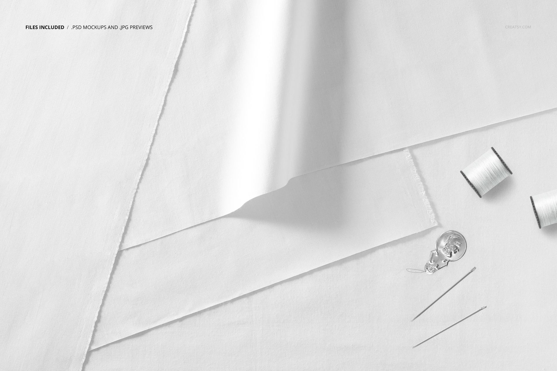 Fabric layers mockup showing overlapping white cloth sheets with sewing accessories placed on a neutral background.