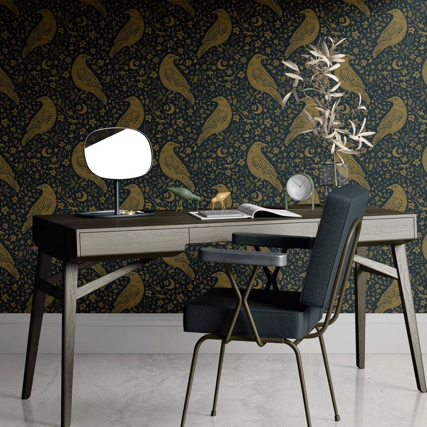 Interior scene with a modern desk mockup, featuring a dark chair, decorative mirror, clock, and patterned wallpaper with gold crows.