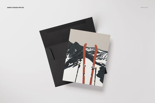A2 card mockup with a mountain and ski design, paired with a black envelope, shown from a top view on white background.