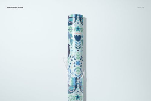 Gift wrapping paper mockup roll with stylized floral and bird motifs in blue and green, displayed vertically.