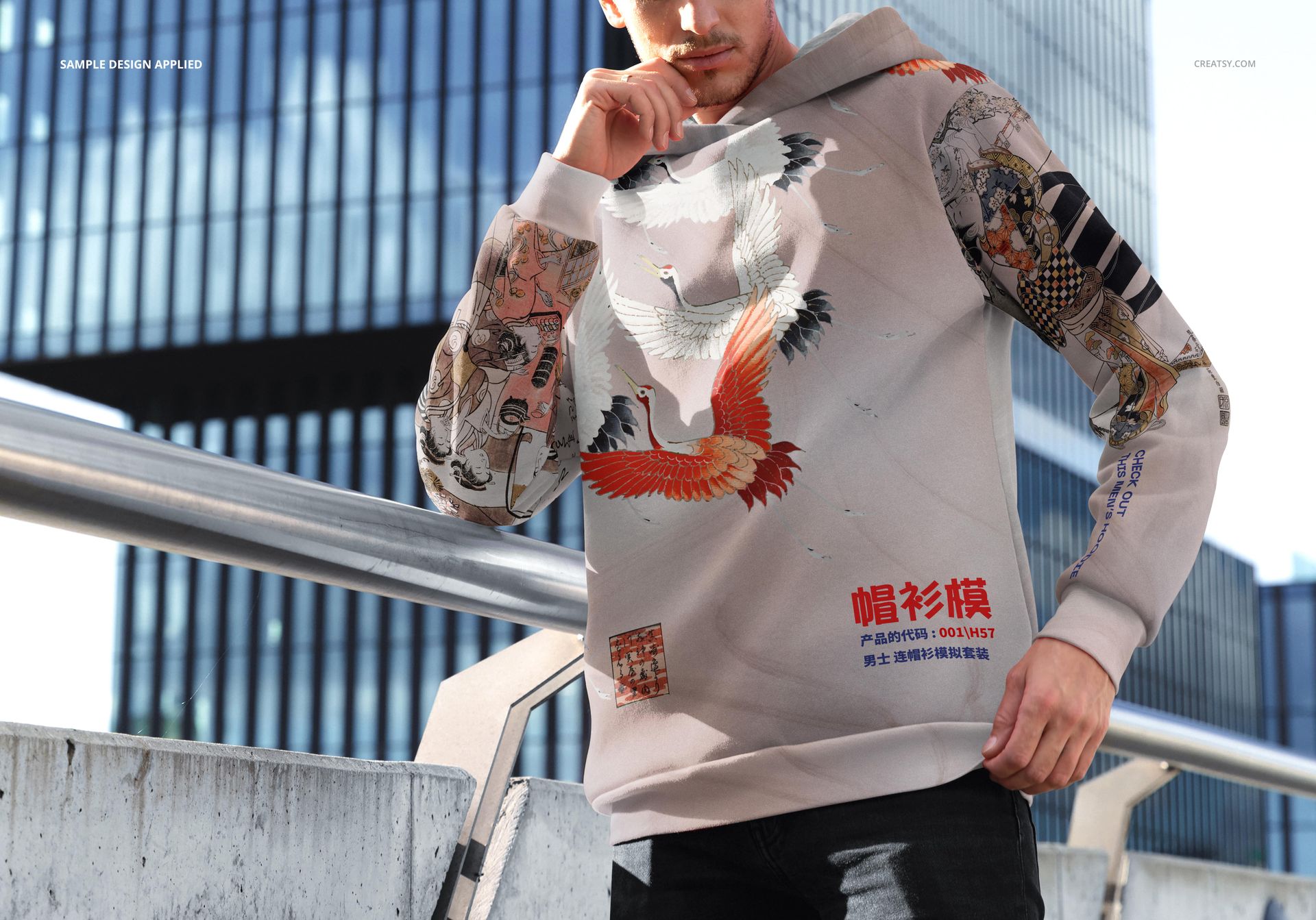 Outdoor scene showing a male model in a PSD mockup of an oversized hoodie with vibrant graphic prints and large hood.