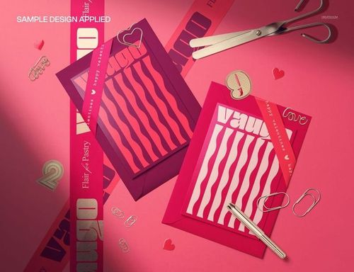 Valentine’s Day greeting card PSD mockup featuring two cards, envelopes, ribbons, and heart-shaped paper clips on a pink surface.
