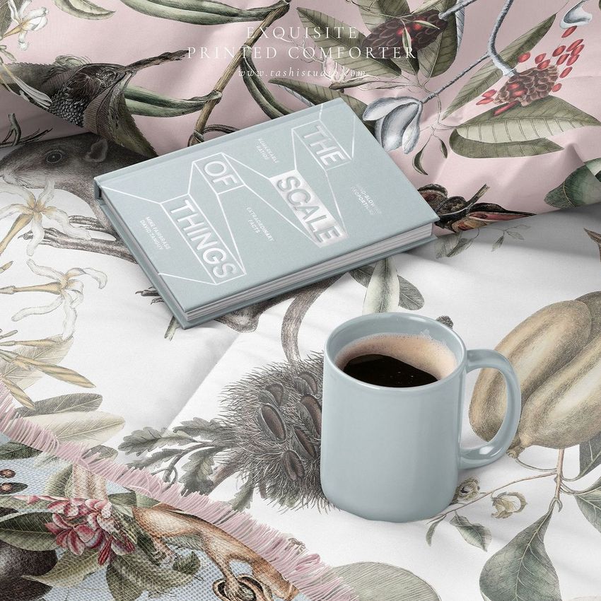 Microfiber comforter mockup featuring a botanical print, with a light blue mug of coffee and a book placed on top.