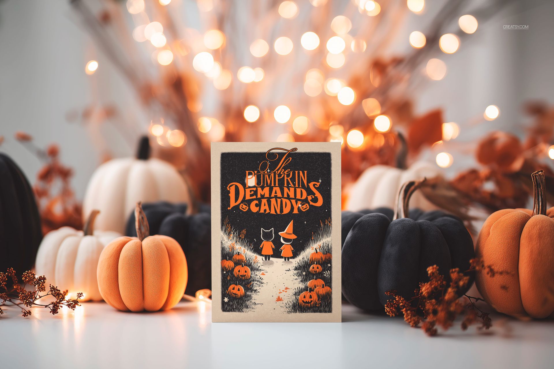 Halloween greeting card mockup standing upright among orange and black pumpkins, with blurred lights in the background.