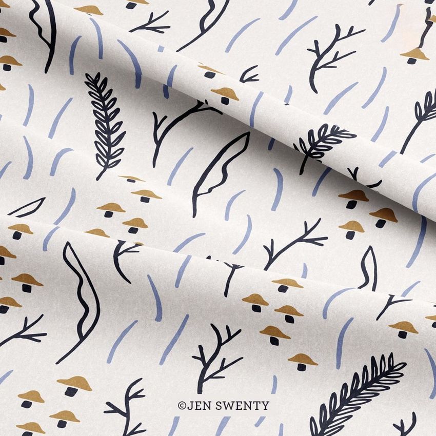 Lying fabric mockup featuring a whimsical pattern of mushrooms, leaves, and abstract lines in muted browns and blues on a light background.