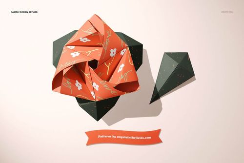 Paper origami rose mockup featuring orange petals with white flowers and green leaves, displayed on a neutral surface.