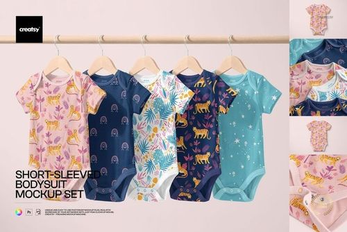 Row of baby bodysuits with various animal and rainbow prints displayed on hangers, light background, PSD mockup.