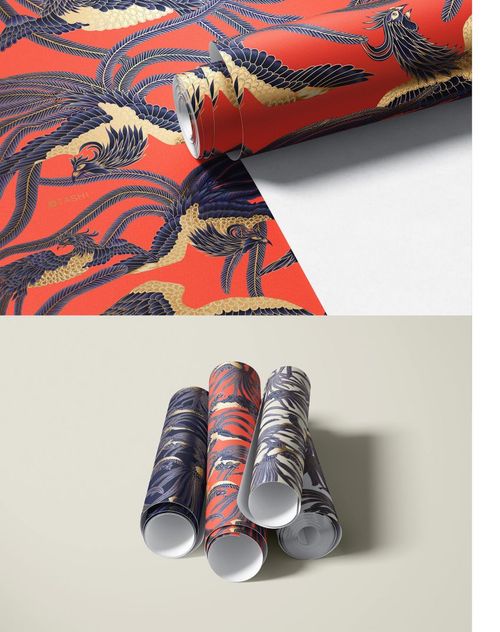 Rolled paper wallpaper mockups featuring bold bird and feather patterns in red, gold, and navy tones on a neutral background.